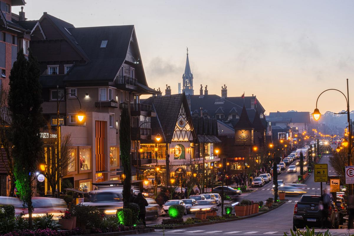 Imagem de uma pessoa trabalhando em um laptop em uma varanda com vista para o cenário tranquilo e verde de Gramado, exemplificando um ambiente ideal para trabalhar remotamente.